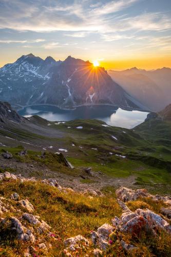 a sunset over a mountain range with a lake at Hotel Gasthaus Schäfle in Bürserberg