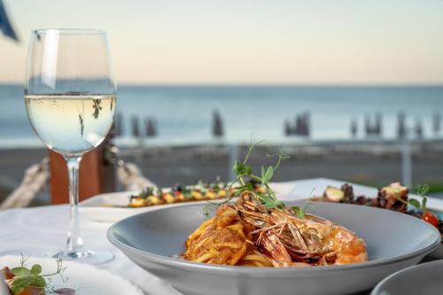 a plate of food on a table with a glass of wine at Rodos Palladium Leisure & Wellness in Faliraki