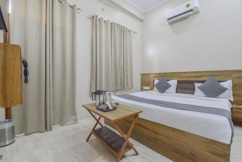 a bedroom with a large bed and a table at Hotel Shivansh, RIICO Mansarovar in Jaipur