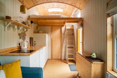 a tiny house with a kitchen and a loft at Ailsa- Enchanting Tiny House with wood burner and hot tub in Cairngorms in Ballater