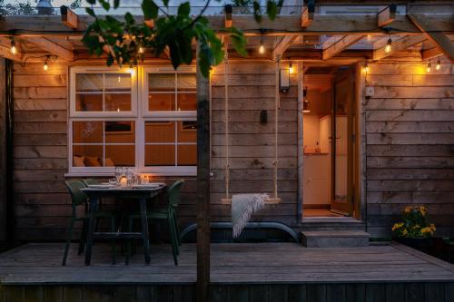 a patio with a table and chairs on a deck at Ailsa- Enchanting Tiny House with wood burner and hot tub in Cairngorms in Ballater