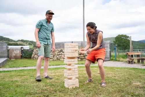 a man and woman playing with bricks in a yard at Ailsa- Enchanting Tiny House with wood burner and hot tub in Cairngorms in Ballater