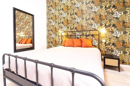 a bedroom with a bed with orange pillows and a mirror at Séjour tout confort Emplacement exceptionnel in Rennes
