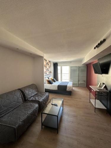 a living room with a couch and a bed at City Loft Apparthotel in Dijon