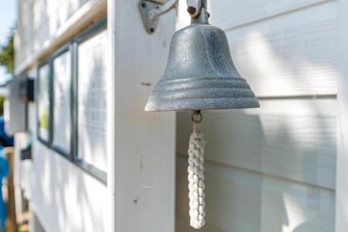 a bell hanging on the side of a building at Surfbrett 1 - Zimmer mit Deichblick in Dahme