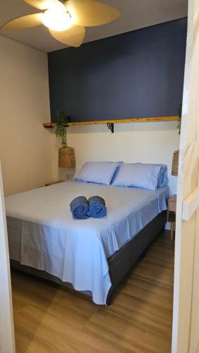 a bedroom with a bed with blue pillows on it at Loft Santorini no centro com Café da manhã in Alto Paraíso de Goiás