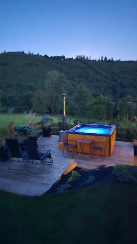 a patio with a pool and two chairs and a table at Hasiorówka Dom w górach z jacuzzi w cenie in Złatna