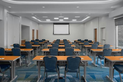 an empty classroom with tables and chairs and a whiteboard at SpringHill Suites by Marriott Idaho Falls in Idaho Falls