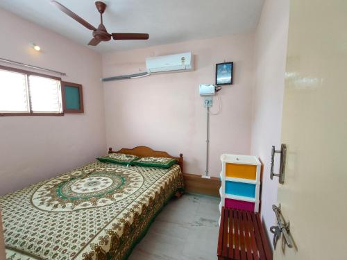 a bedroom with a bed and a ceiling fan at Green house in Tiruvannāmalai