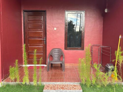 a chair sitting outside of a red house at Raflow Resort Raja Ampat in Tapokreng