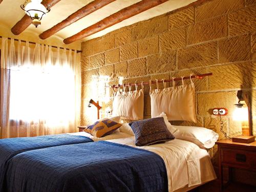 a bedroom with a bed with a blue comforter at Casa Mairal in Salillas