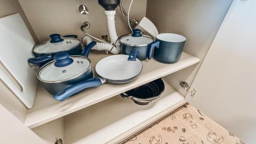 a shelf with pots and pans on it at Apt Afeto Pomerode in Pomerode