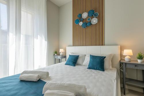 a bedroom with a large white bed with blue pillows at Binda 21-2F charme moderno Navigli - Vesta in Milan