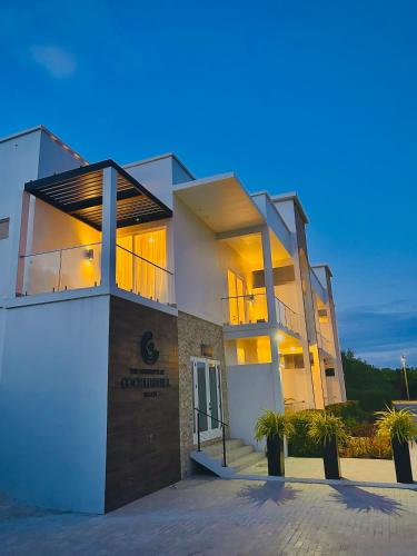 a large white building with its lights on at Cockleshell Villas in Basse Terre Town