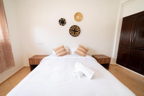 a bedroom with two beds with white sheets at Appartement Dar Tamraght in Tamraght Ouzdar