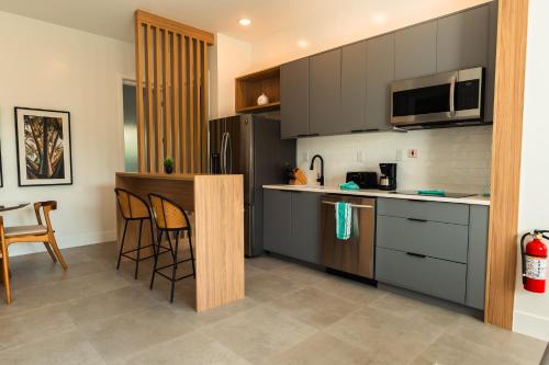 a kitchen with gray cabinets and a table and chairs at Cockleshell Villas in Basse Terre Town
