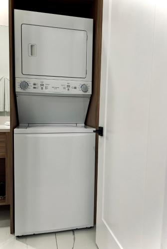 a white refrigerator with a microwave on top of it at Cockleshell Villas in Basse Terre Town