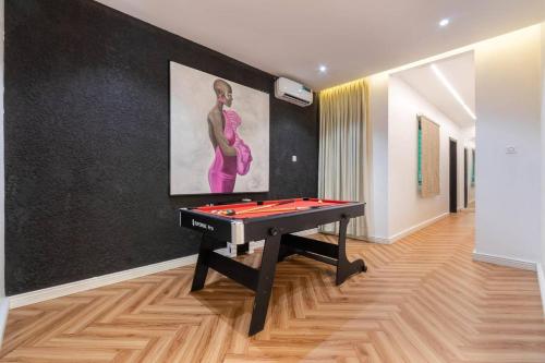 una mesa de ping pong en una habitación con una pintura en Exclusive 3 Bedroom apartments with pool and high grade amenities, en Lagos