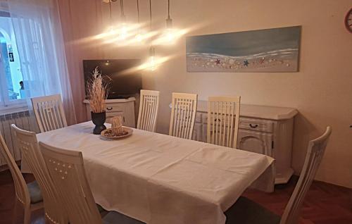 a dining room table and chairs with a white table and a table and chairsktop at Villa Lara - Rab by Villas Guide in Rab