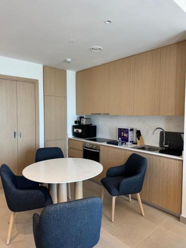 a kitchen with a table and chairs in a room at Address Residence Marassi Vista-studio in Amwaj Island