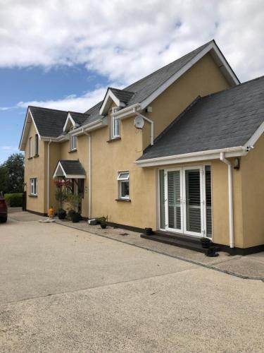 a yellow house with a gray roof at Wellfield house in Wexford