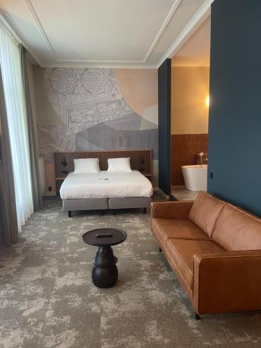a hotel room with a bed and a couch at Fletcher Hotel Paleis Stadhouderlijk Hof in Leeuwarden
