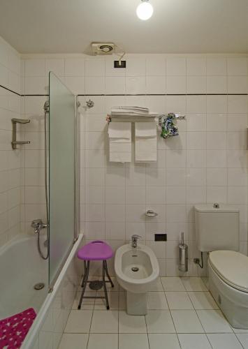 a bathroom with a toilet and a sink and a shower at Hotel Rex in Lucca