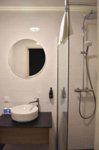 a bathroom with a sink and a shower with a mirror at Fletcher Hotel Paleis Stadhouderlijk Hof in Leeuwarden