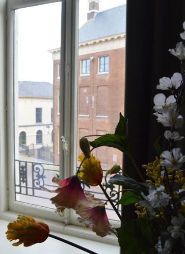 a window with a bunch of flowers in a vase at Fletcher Hotel Paleis Stadhouderlijk Hof in Leeuwarden