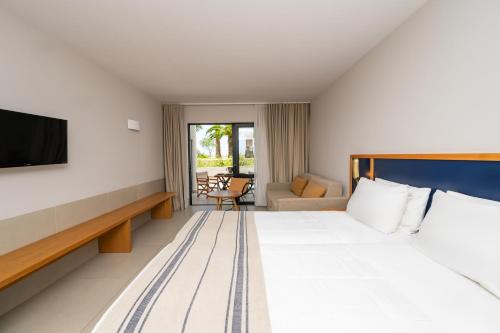 a hotel room with a bed and a tv at Smy Kos Beach & Splash in Mastichari