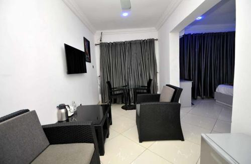a living room with a couch and chairs and a table at Chakaville Beach Resort in Iberekodo