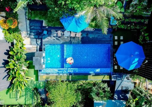 an overhead view of a swimming pool with an umbrella at Jukung Villa Lampung in Hajimana