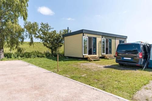 a van parked in front of a tiny house at Surfbrett 1 - Zimmer mit Deichblick in Dahme