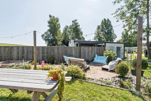 a backyard with a wooden bench and a fence at Surfbrett 1 - Zimmer mit Deichblick in Dahme