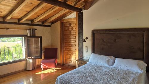 a bedroom with a bed and a chair and a window at Antiguas Eras La Alberca in La Alberca