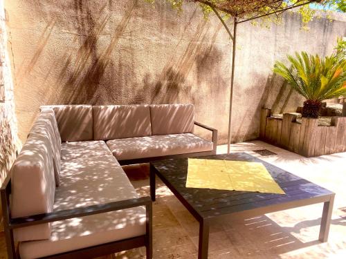 a couch and a coffee table on a patio at Le relais de l'ancienne poste in Sigoulès