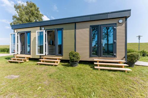 a tiny house with benches in front of it at Surfbrett 1 - Zimmer mit Deichblick in Dahme