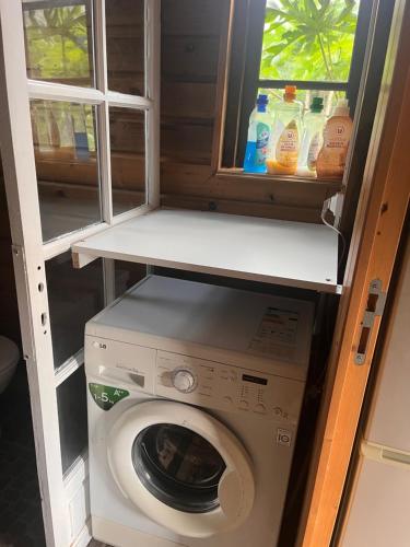 a washing machine in a room with a window at LaKour Fleurie Chambres d hôtes in Sainte-Rose