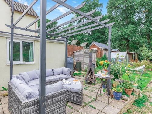 a patio with a couch under a pergola at Oak Villa in Cinderford