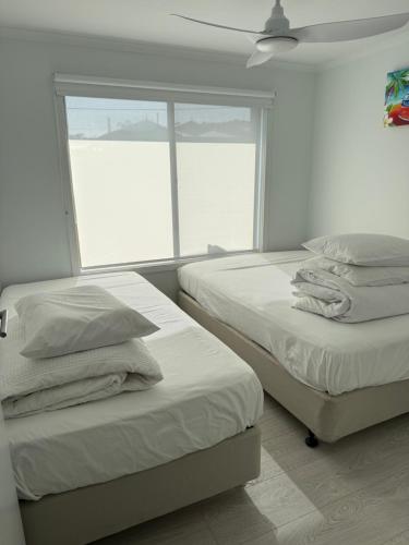 two beds in a room with a window at Beach House Getaway 2 in Smiths Beach