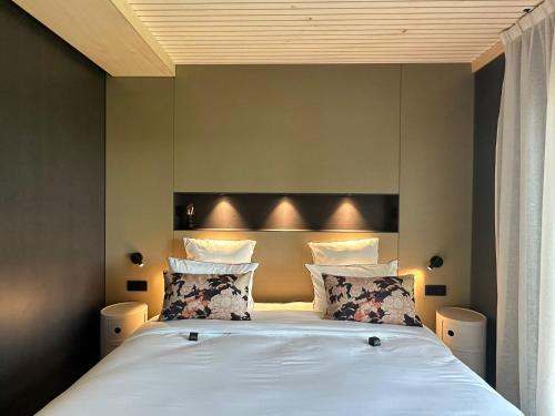 a bedroom with a bed with white sheets and pillows at James Vignoble Hôtel, Eguisheim in Eguisheim