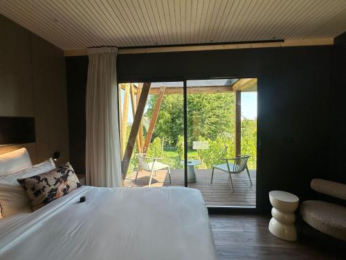 a bedroom with a bed and a sliding glass door at James Vignoble Hôtel, Eguisheim in Eguisheim