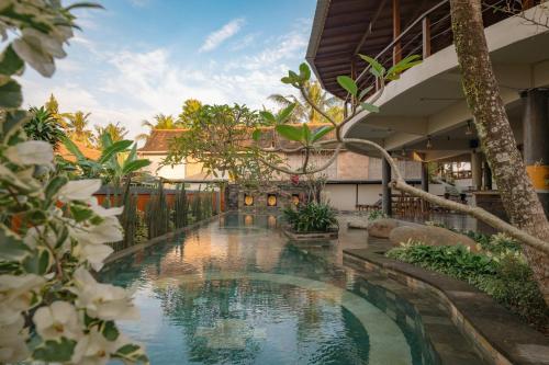 a pool in the middle of a building with trees at Artropeace Ubud Retreat & Villas in Ubud