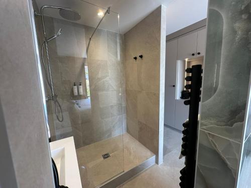 a bathroom with a shower with a glass door at James Vignoble Hôtel, Eguisheim in Eguisheim