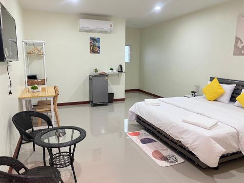 a bedroom with a bed and a table and chairs at Muttafa House in Nai Yang Beach