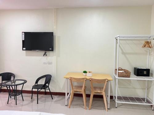 a dining room with a table and chairs and a tv at Muttafa House in Nai Yang Beach