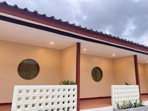 a house with two windows and a white fence at Muttafa House in Nai Yang Beach