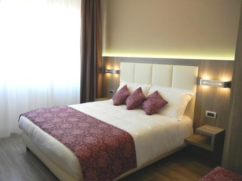 a bedroom with a large bed with purple pillows at Delle Nazioni Milan Hotel in Milan