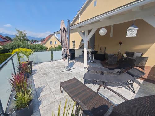 a patio with chairs and tables and an umbrella at Großzügige Wohnung mit Terrasse in Zeltweg
