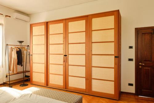 a closet with wooden doors in a room at Villa Montalban Ghetti - La Fiorita in Conegliano